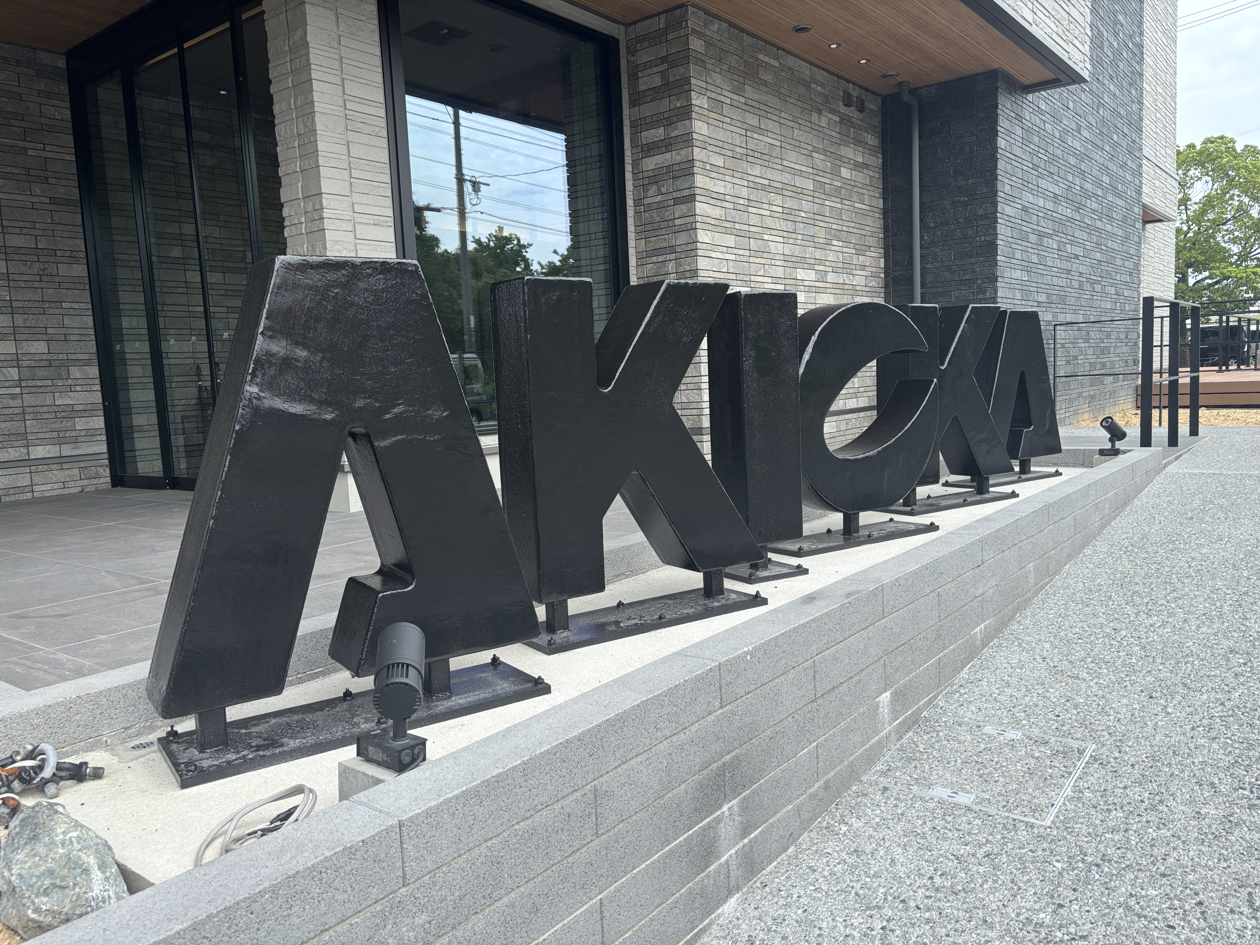 新社屋正面に設置されたAKIOKAロゴ